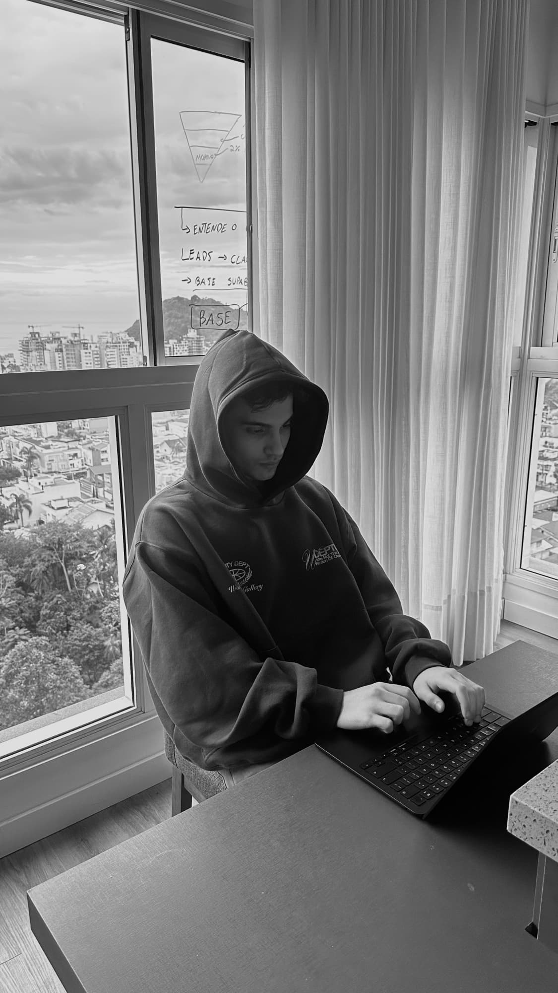 Davi Castro construindo no computador ao lado de um quadro de estratégia
